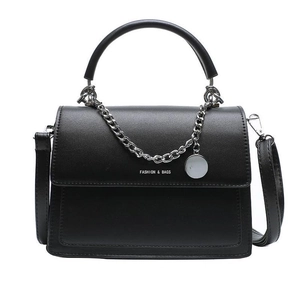 Minimalist black leather handbag with silver chain detail and circular pendant charm