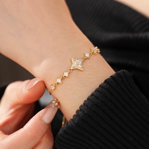 Close-up of star-shaped gold bracelet with micro-paved zircons on a model's wrist