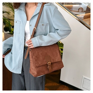 Detailed close-up of brown faux suede texture with leather buckle on a retro tote bag