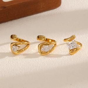 Three gold zirconia rings with teardrop, marquise and square cuts on a textured display