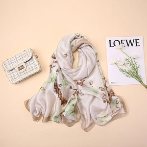 Detailed view of elegant floral print silk scarf with luxury tweed gold chain handbag