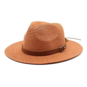 Close-up of woven straw panama hat with brown leather band and silver metal ring detail