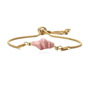 Detail of a gold adjustable box chain bracelet with a pink conch shell pendant