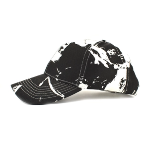 Detail view of tie-dye baseball cap featuring black and white abstract splatter texture