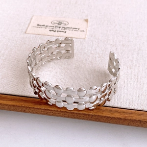 Detailed macro shot of silver hollow-out braided mesh bangle with geometric pattern