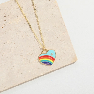 Elegant gold heart pendant necklace with rainbow enamel and zircon on beige stone