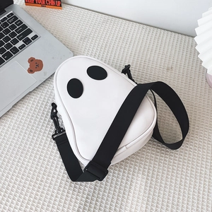 Detail shot of a cute ghost-shaped PU leather crossbody bag with adjustable black strap