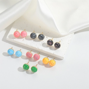 Detailed macro view of small round marble pattern stud earrings in multiple colors