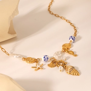 Detail of ocean-style gold necklace featuring seahorse, starfish, and shell charms