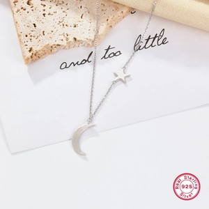 Minimalist S925 sterling silver star and moon pendant necklace on a premium silk background