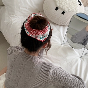 Detail of red and white plaid hair scrunchie with floral lace on a bun hairstyle