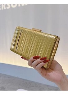 Close-up of golden pleated clutch bag featuring metallic texture and snap closure