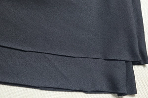 Gros plan sur la texture du tissu noir montrant le tissage sergé détaillé et la qualité