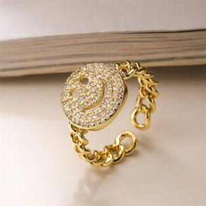 Close-up of gold-plated smiley face ring with micro-paved cubic zirconia crystals
