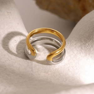 Macro view of bicolor 18k gold and silver stainless steel open ring with fluid curves