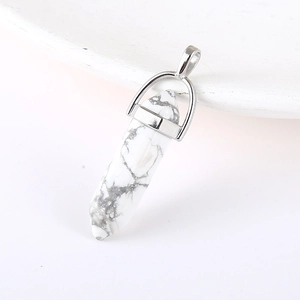 White marble hexagonal prism pendant with silver metallic clasp on a clean white tray