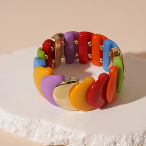 Close-up of colorful acrylic heart bead bracelet with metal spacers on stone stand