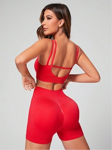 Dettaglio dei pantaloncini yoga rossi a vita alta e del reggiseno sportivo a costine