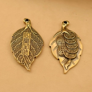Macro detail of copper leaf charms with embossed Chinese characters and coins
