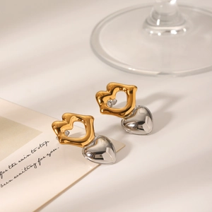 Two-tone gold and silver heart earrings placed on a decorative white card with calligraphy