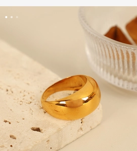 Gros plan détaillé d'une bague bombée dorée minimaliste sur une surface en pierre