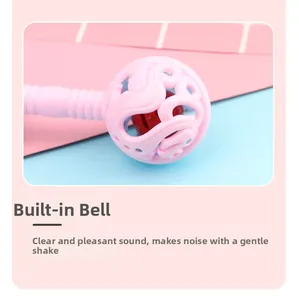 Detail of pink baby rattle showing built-in red bell and textured easy-grip handle