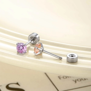 Pink and orange gradient zircon stud earrings with silver bases on ceramic dish