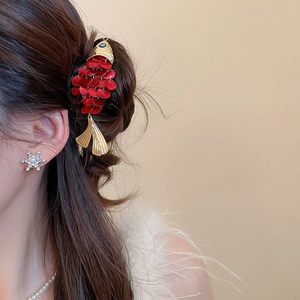 Detailed shot of koi fish hair clip with red enamel and gold metal on hair