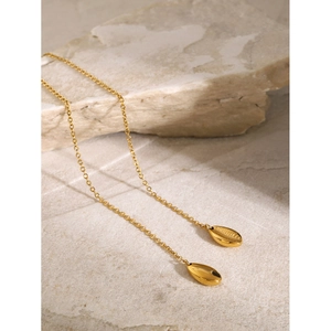 Detail of 18k gold plated stainless steel long chain necklace with shell pendants on stone