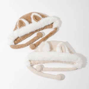Detail of plush fox ear hats in brown and beige showing soft faux fur and pompom ties