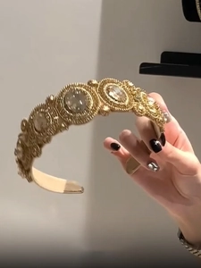 Detailed close-up of a vintage golden headband featuring luxury clear crystals and rhinestones