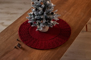 Macro shot of red cable knit texture on a mini Christmas tree skirt for holiday decor