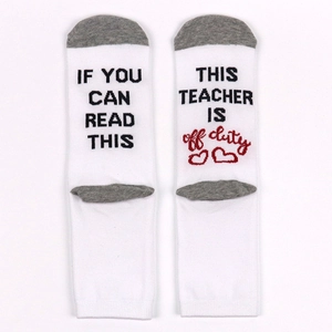 White cotton crew socks featuring grey accents and humorous 'Teacher off duty' text on soles