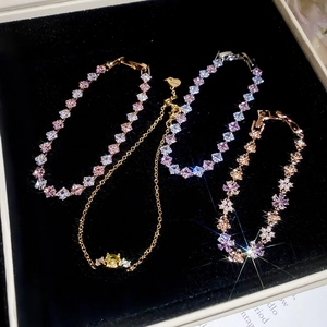Macro shot of colorful crystal flower bracelets with pearls on black velvet background