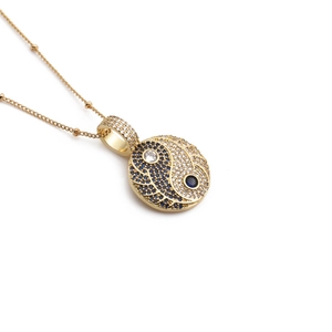 Golden Bagua pendant necklace with blue and white pavé cubic zirconia on white background