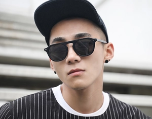 Fashionable round frame sunglasses in black with vintage rivet detail on male model