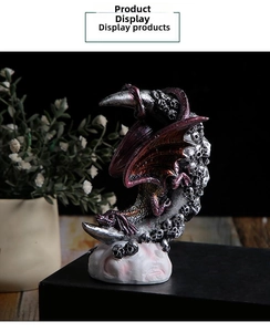 Detail of dragon and skull figurine with metallic finish on crescent moon base