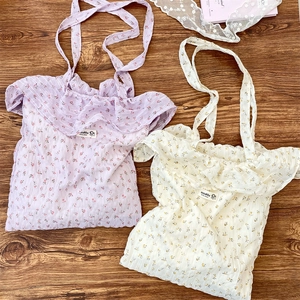 Flat lay of floral chiffon tote bags with ruffled edges in purple and beige tones