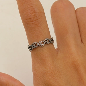 Macro shot of a silver adjustable ring featuring hollow cat paw and footprint motifs