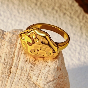 Macro view of golden stainless steel ring with unique irregular molten lava texture