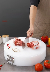 Macro detail of thick round white PE cutting board with stainless steel handle