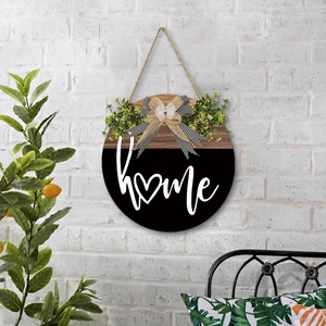 Round wooden home door hanger with heart motif and decorative bow on white brick wall
