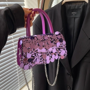 Detail of purple sequin handbag with silver chain strap and elegant top handle design