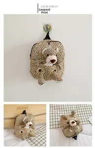 Detail view of tiger print kids backpack with detachable plush doll and hanging handle