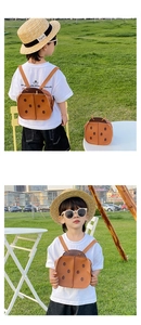 Toddler wearing a brown beetle-shaped PU leather backpack in an outdoor park setting