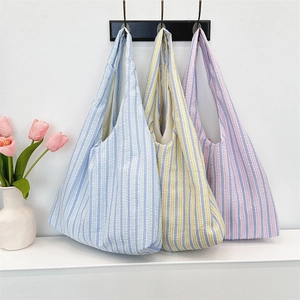 Three colorful striped canvas tote bags hanging on a display stand for daily shopping