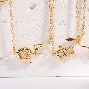 Macro view of 18K gold plated sunflower and floral pendants on refined O-chains