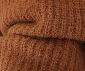 Close-up of caramel mohair cardigan fabric showing fuzzy knit texture and warm material