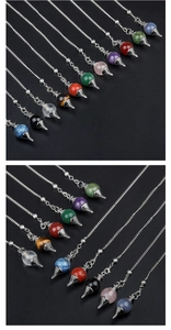 Macro view of multi-colored cone-shaped crystal pendants on silver chains and dark background