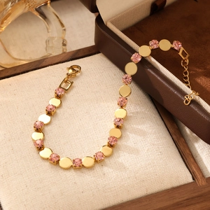 Detail of pink crystal and gold disk bracelet with lobster clasp on jewelry pad